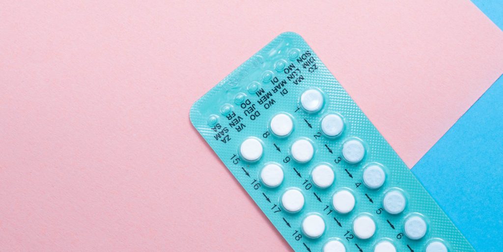 birth control packet on pink background