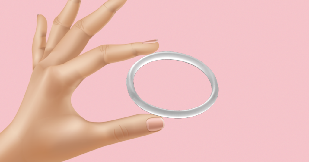 Hand holding a vaginal ring in between thumb and finger