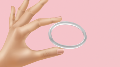 Hand holding a vaginal ring in between thumb and finger