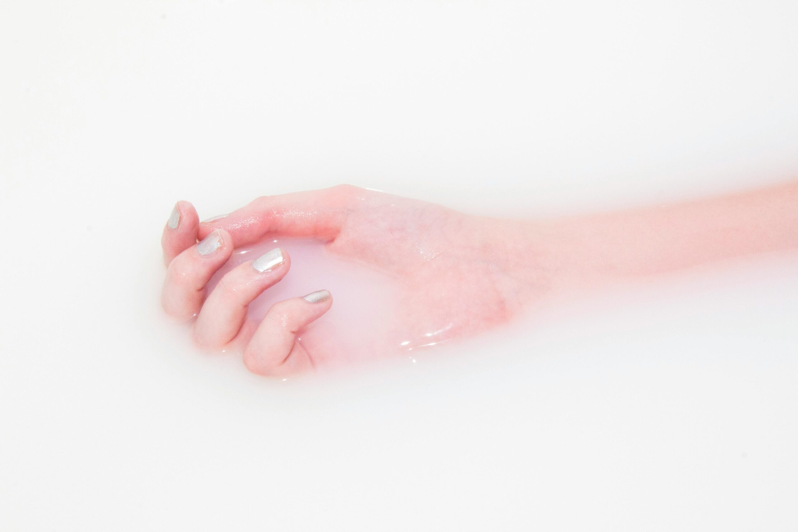 arm resting in bath of milky water