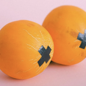 A pair of oranges with nipple tape on