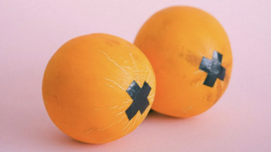 A pair of oranges with nipple tape on